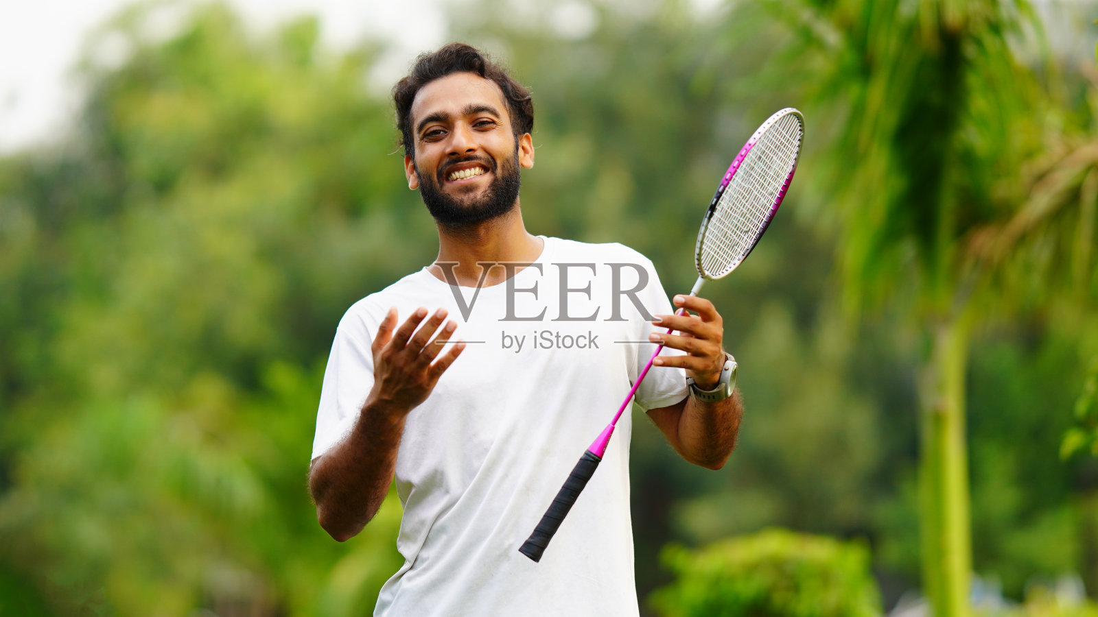 羽毛球运动员心情愉快,在公园里欢笑照片摄影图片