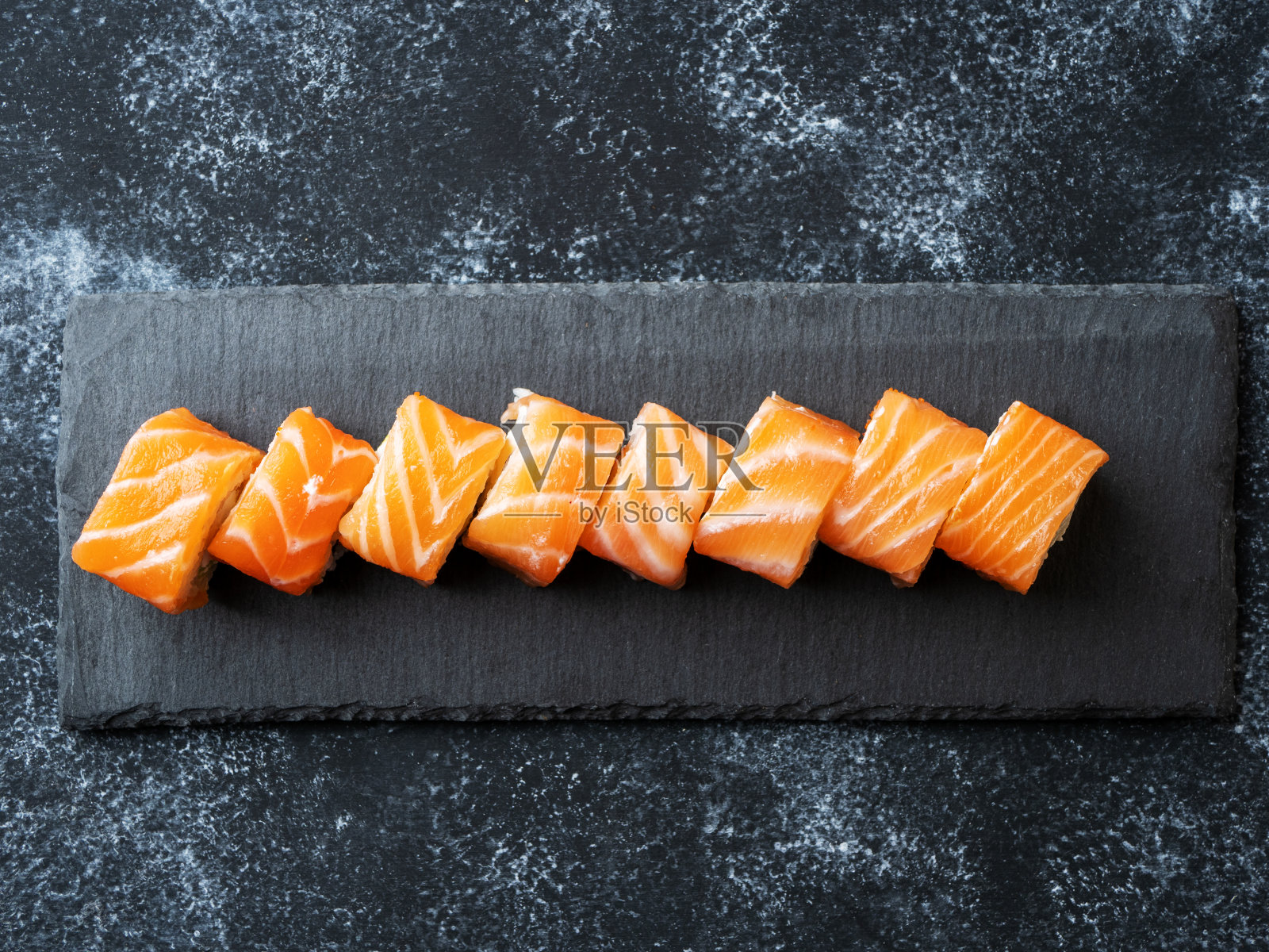 石板上的费城寿司卷,含三文鱼、牛油果和奶油奶酪的寿司套餐照片摄影图片