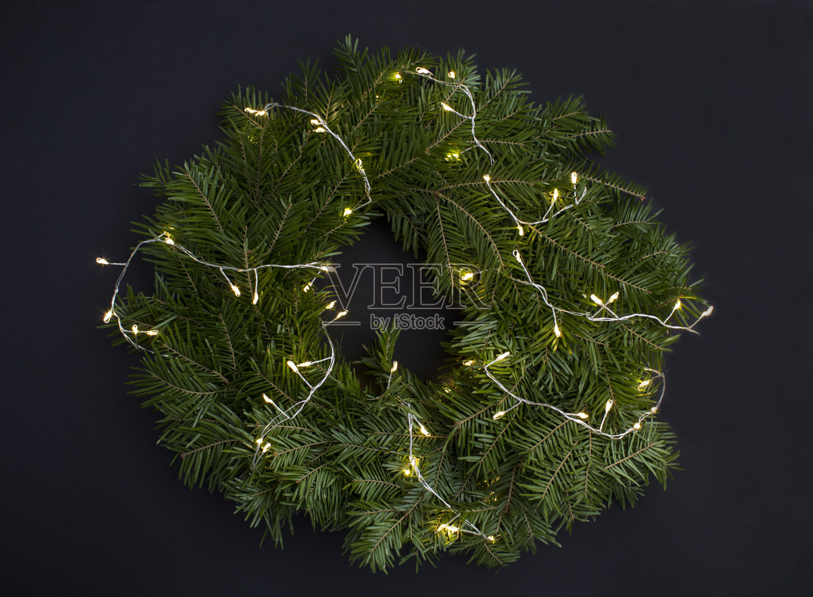 圣诞戒指或花环与发光的花环在黑色的背景。前视图。特写镜头。照片摄影图片