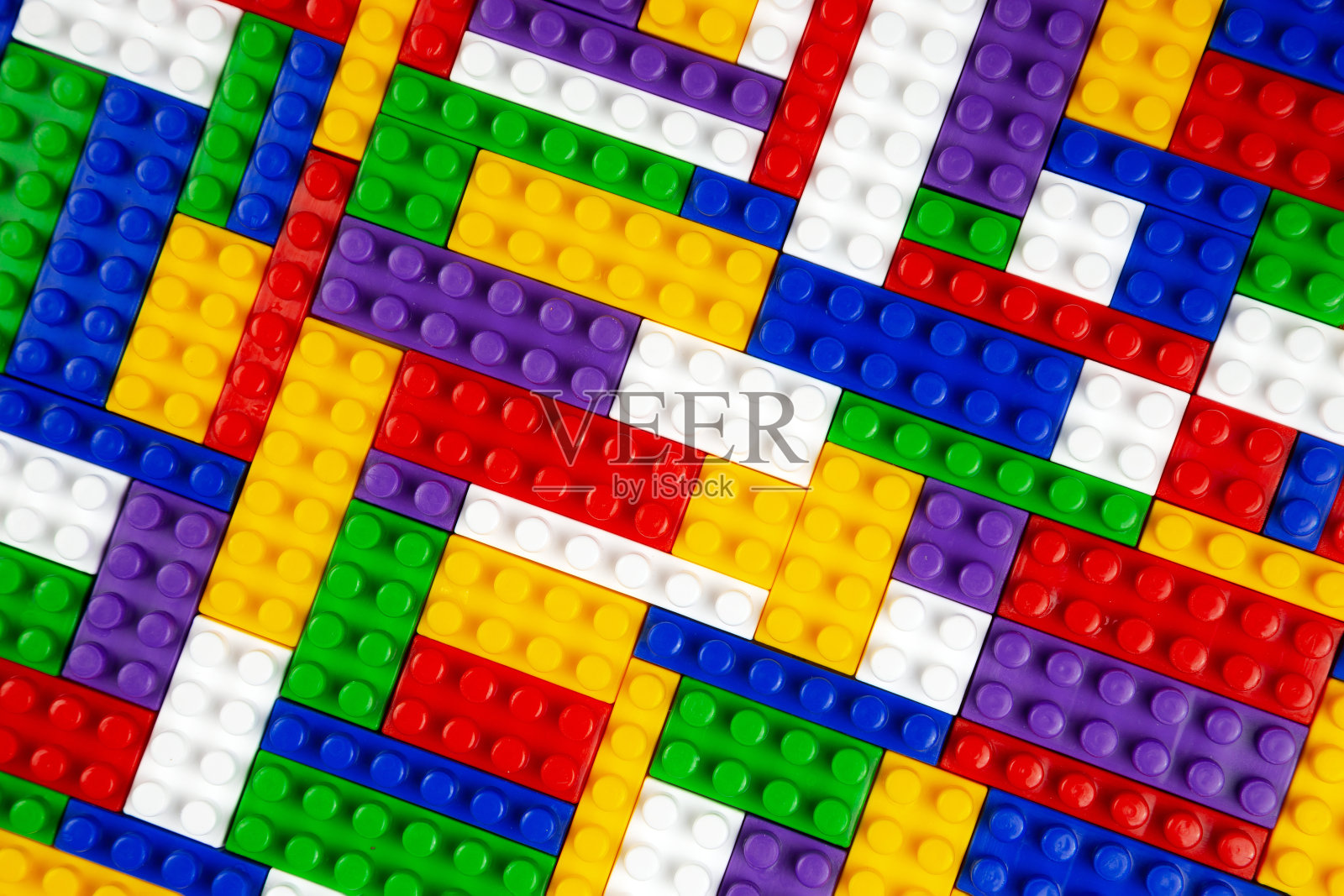 彩色构造函数块的抽象背景纹理。构造器彩色塑料部分的背景。一堆彩色玩具砖。照片摄影图片