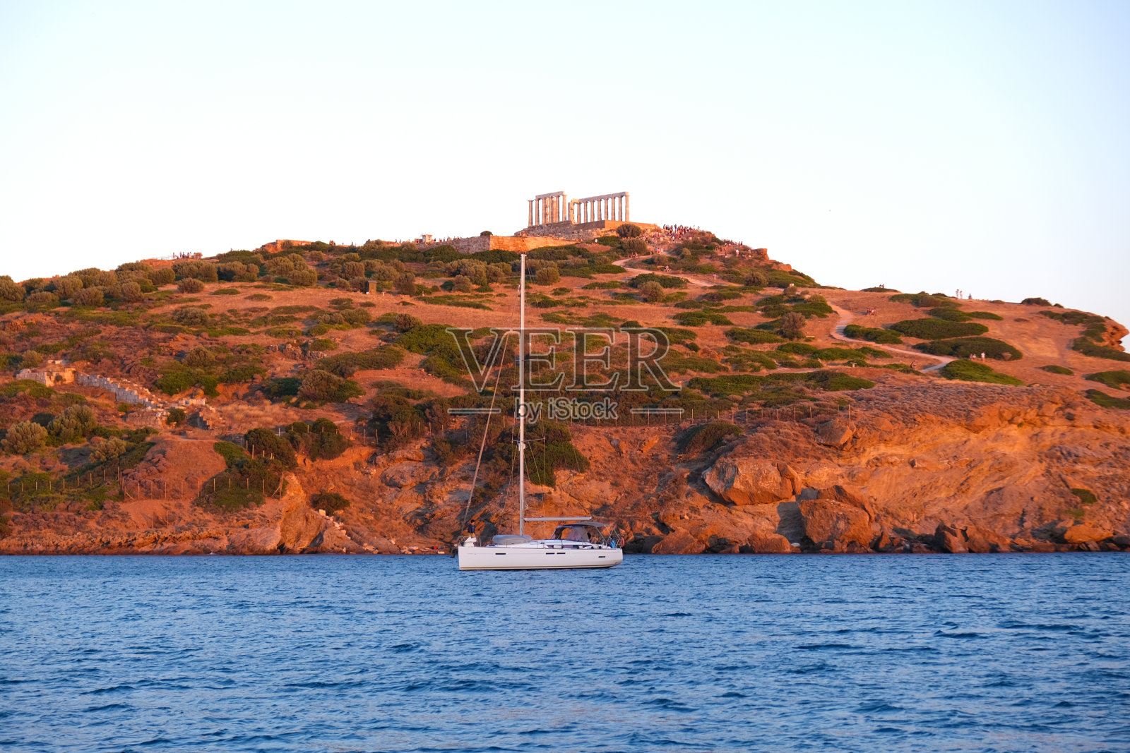 在希腊雅典的苏尼奥角,在夏天的日落时与古代的波塞冬神庙在一起照片摄影图片