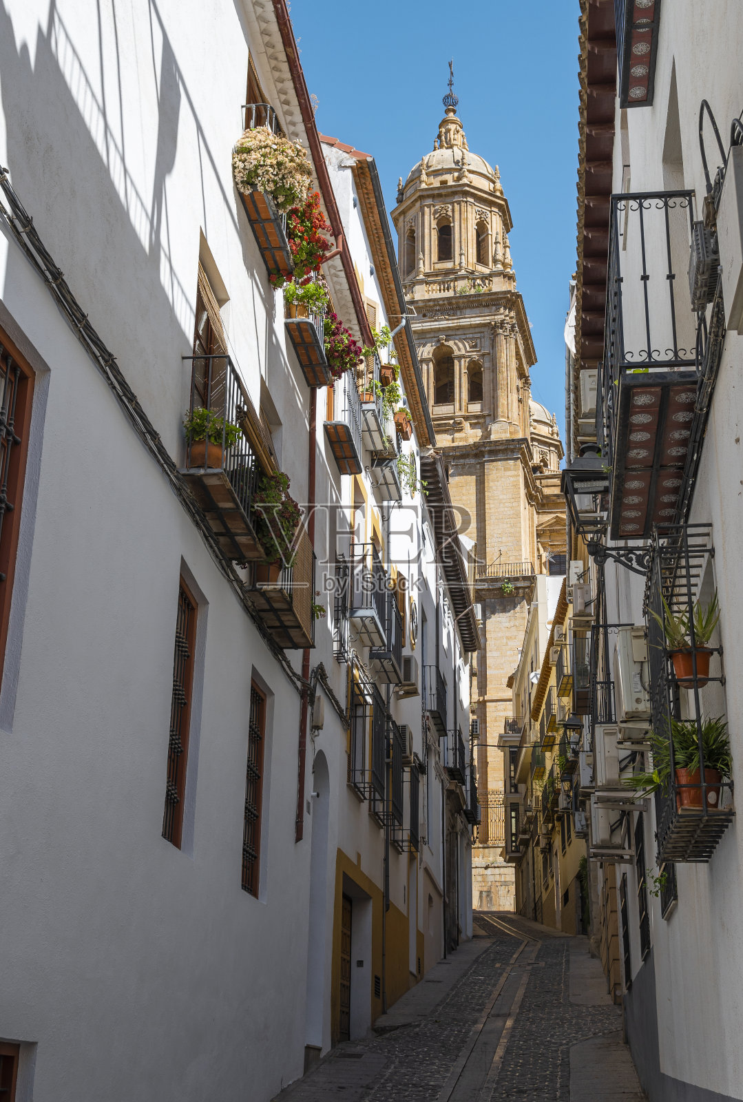 Jaén市的街道,背景是西班牙南部传统的白色房屋和大教堂的钟楼照片摄影图片