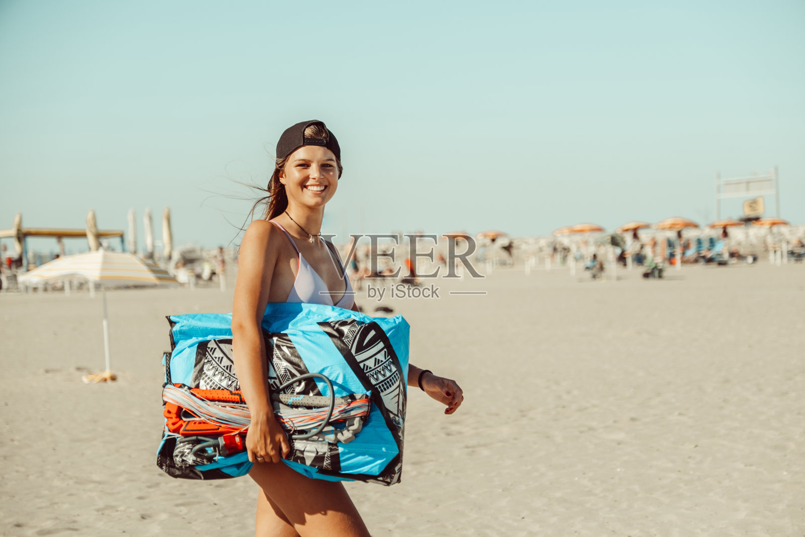 美丽的女人风筝冲浪准备在海滩上的风筝和穿着风筝冲浪设备-运动女人和夏季运动活动的概念照片摄影图片