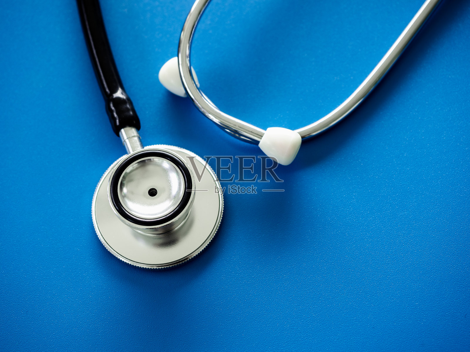 闭合听诊器,蓝色背景,俯视图。医疗保健理念。照片摄影图片