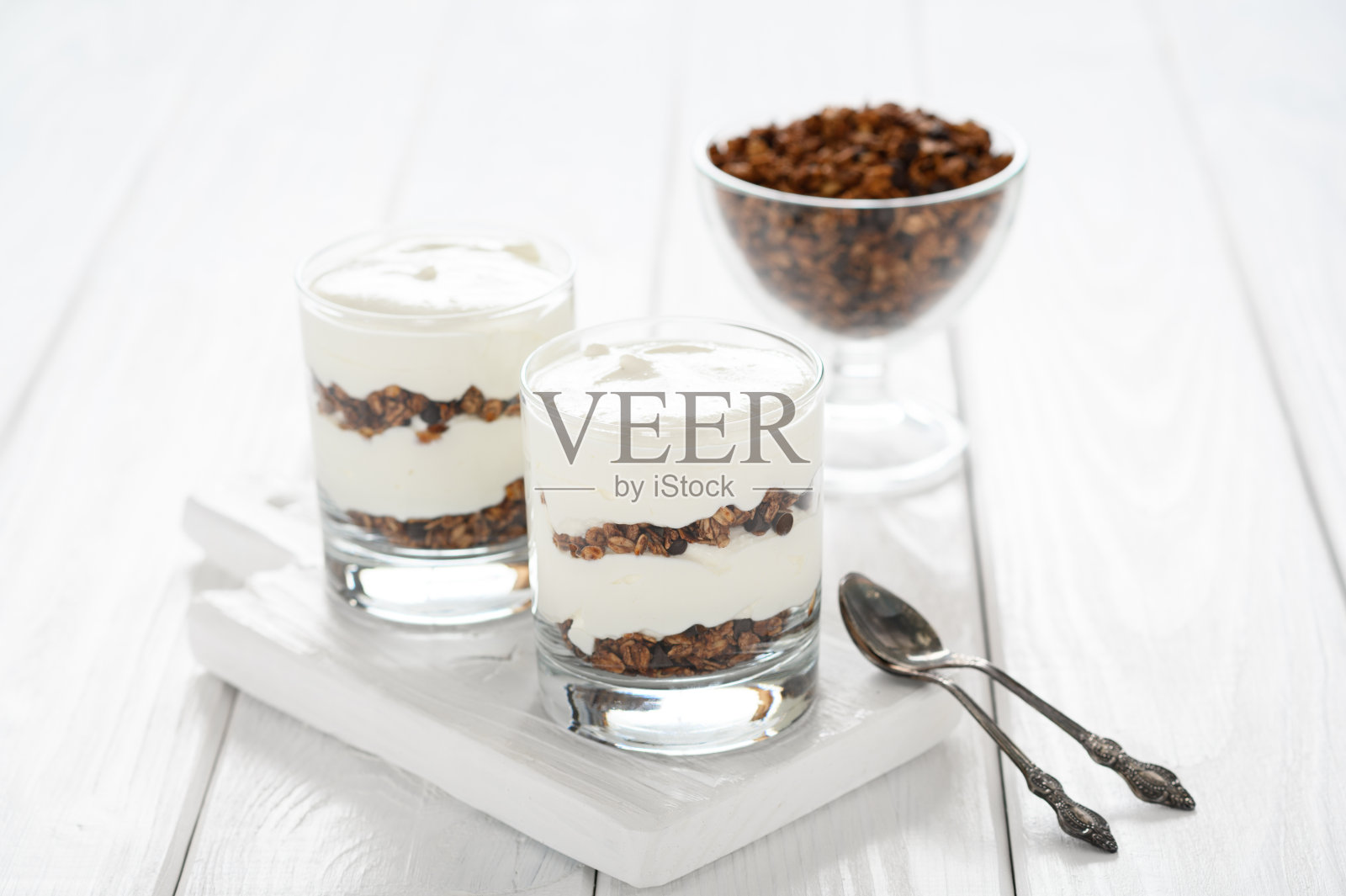 甜点配马斯卡彭奶酪和格兰诺拉麦片,白色木质背景。照片摄影图片