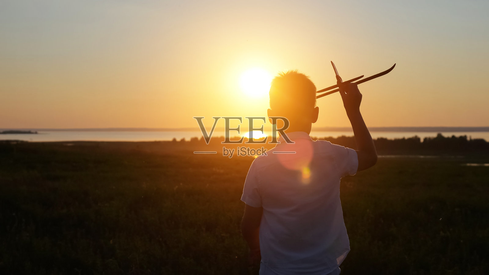 少年在草地上奔跑,直到日落发射飞机照片摄影图片