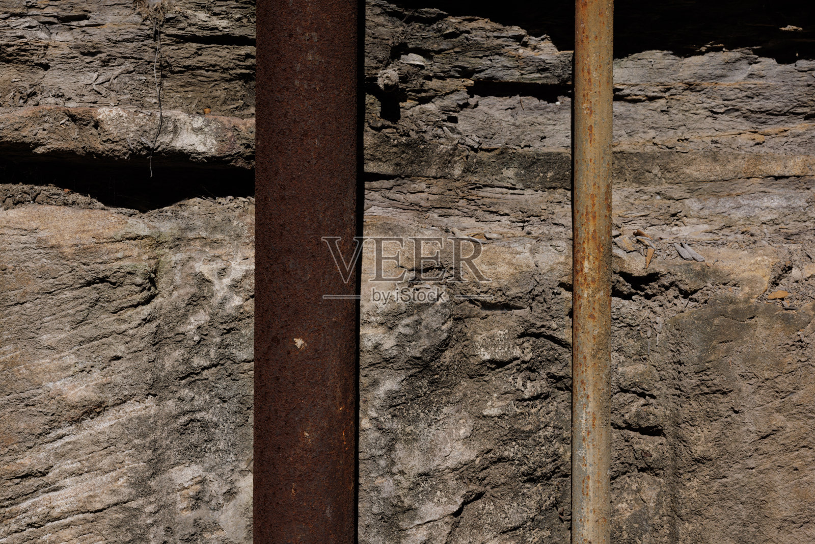 岩石墙上的金属管照片摄影图片