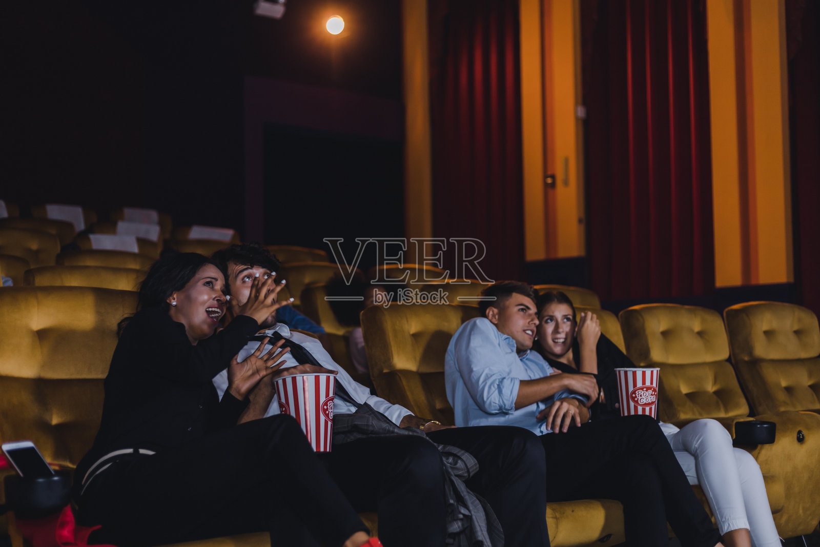 年轻人和成年人看电影都感到害怕和恐怖。照片摄影图片