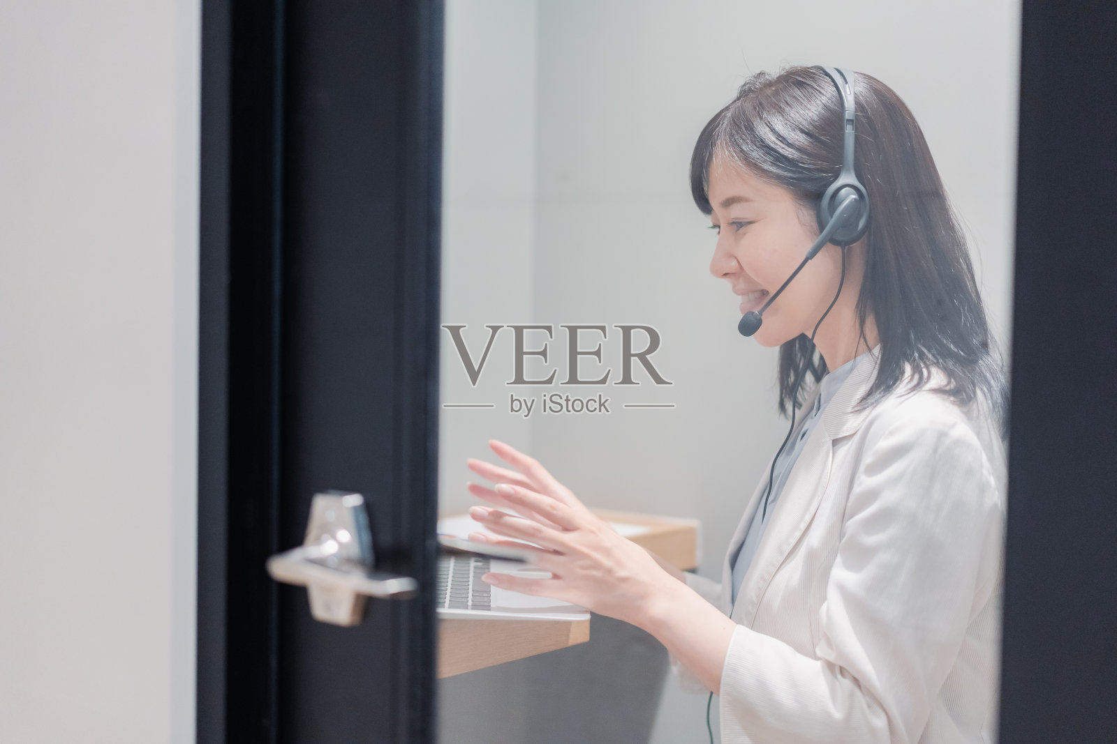 一个女人在共享办公室的私人隔间里开远程会议照片摄影图片