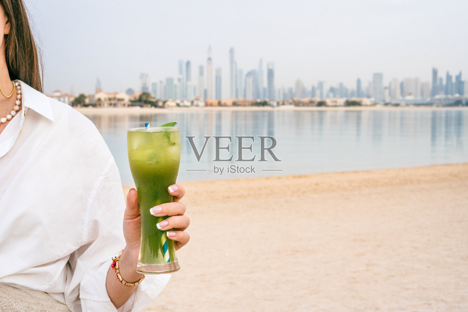 女人在海滩享受无酒精鸡尾酒照片摄影图片