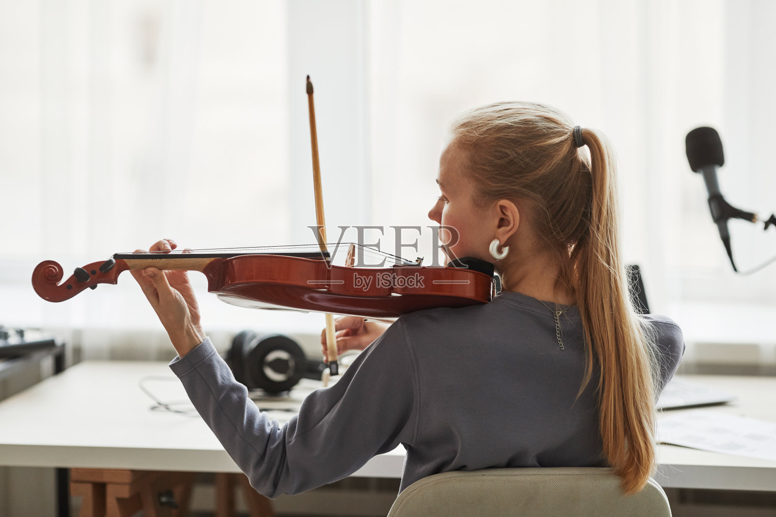 年轻女子在家里演奏小提琴后视图照片摄影图片