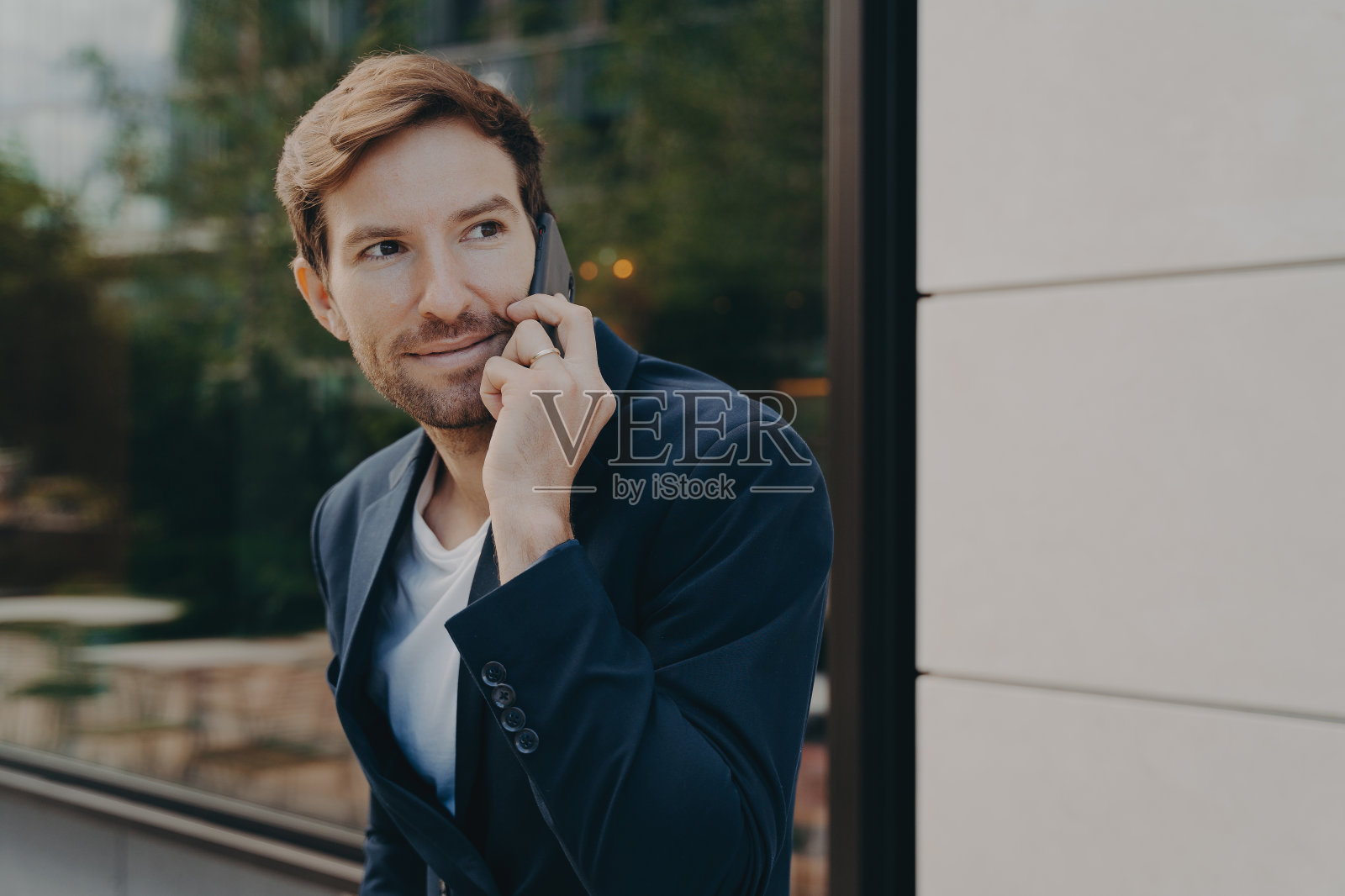 英俊的都市职业商人站在外面听顾客打电话照片摄影图片