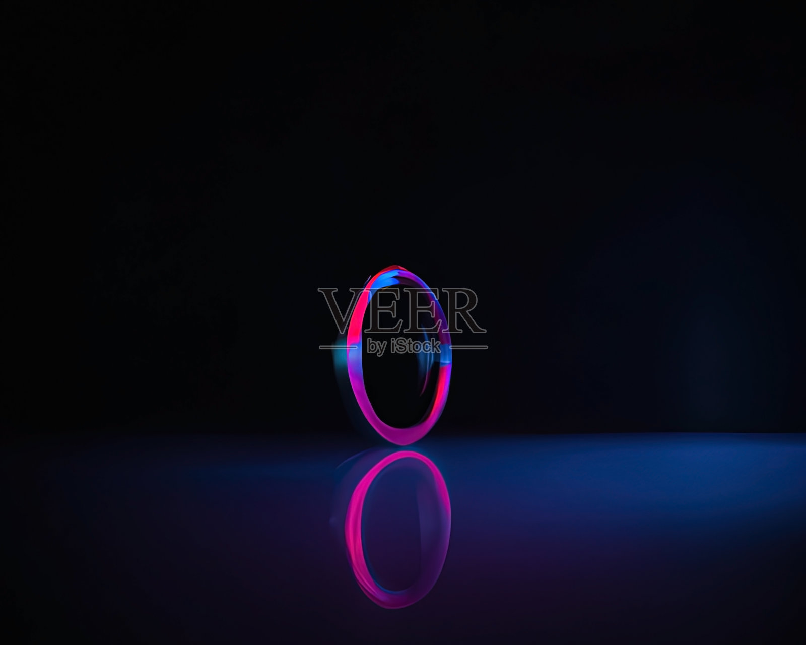 光环,粉红色和蓝色,品红和绿松石与地板上的反射,黑色背景,移动的光环照片摄影图片