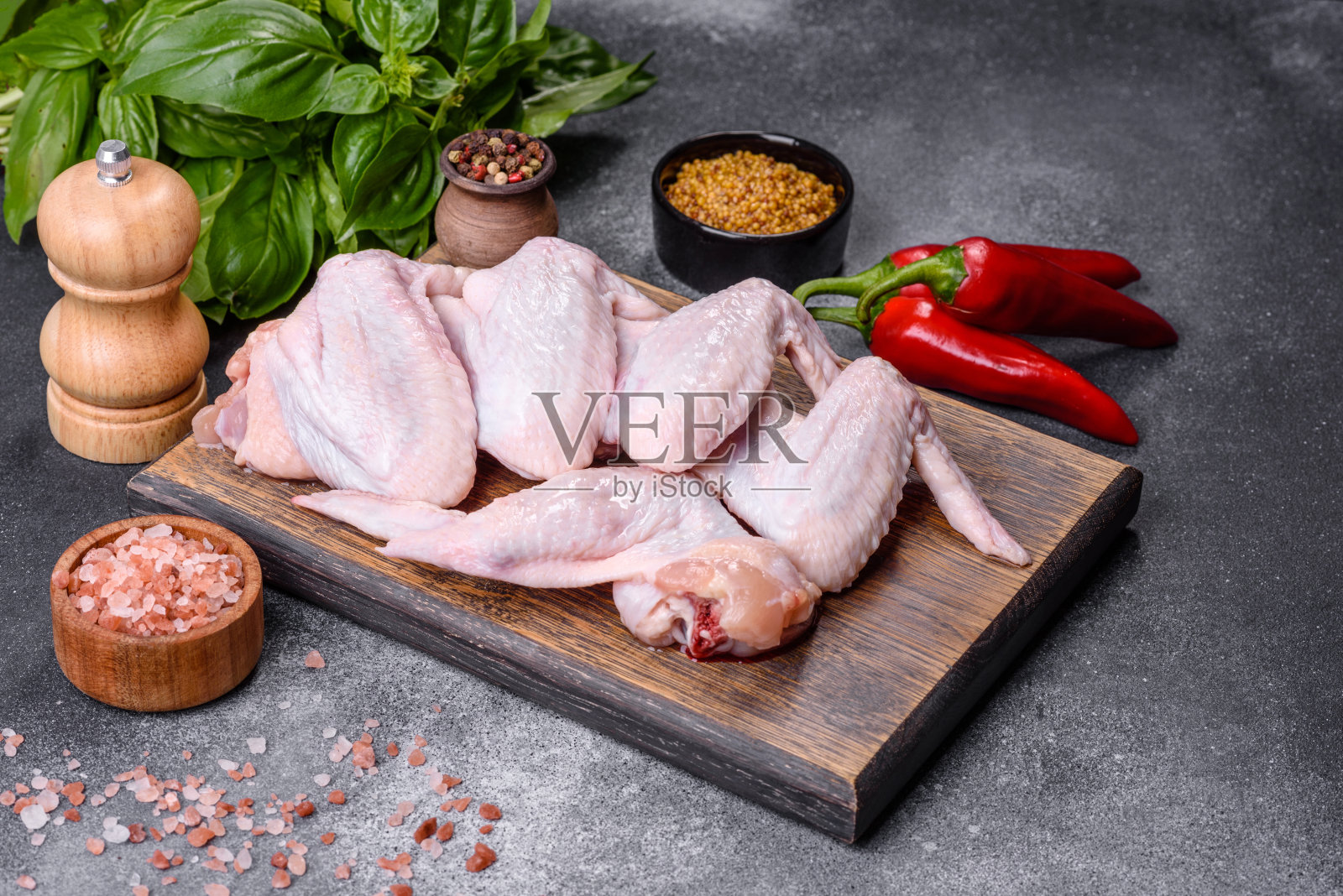 生鸡翅和烹饪食材放在木制砧板上照片摄影图片