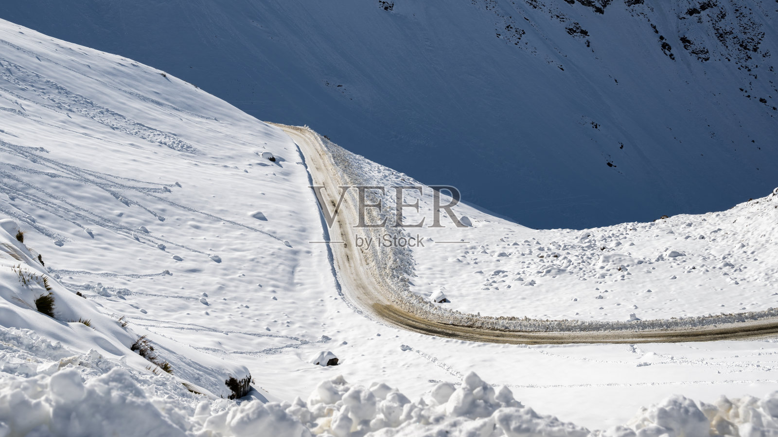 弯弯曲曲的冰雪山路在雪中,Twizel,南岛。照片摄影图片