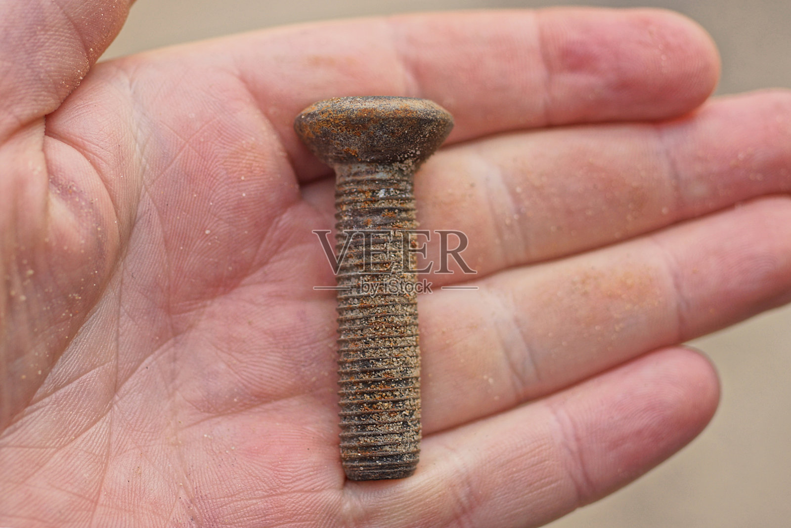 手掌上有一根棕色的生锈的老铁栓照片摄影图片