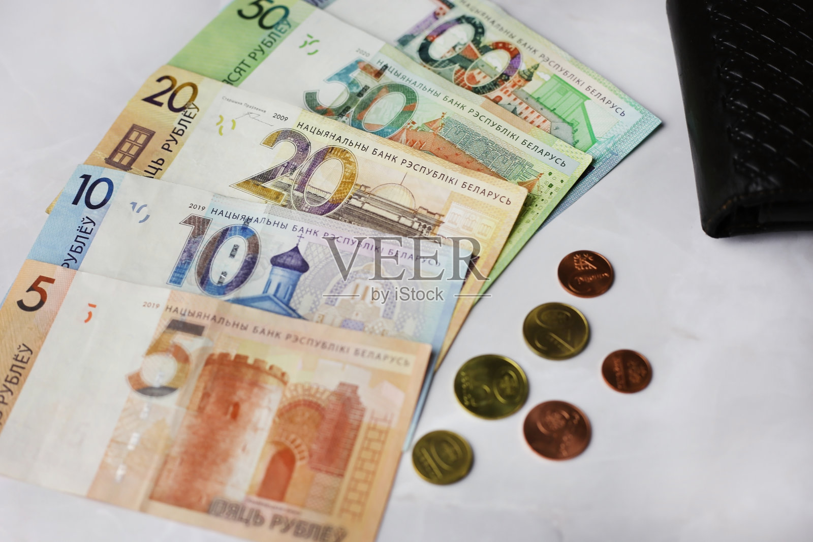 硬币和纸币面额为100,50,20,10.5白俄罗斯卢布,灰色背景的黑色钱包照片摄影图片