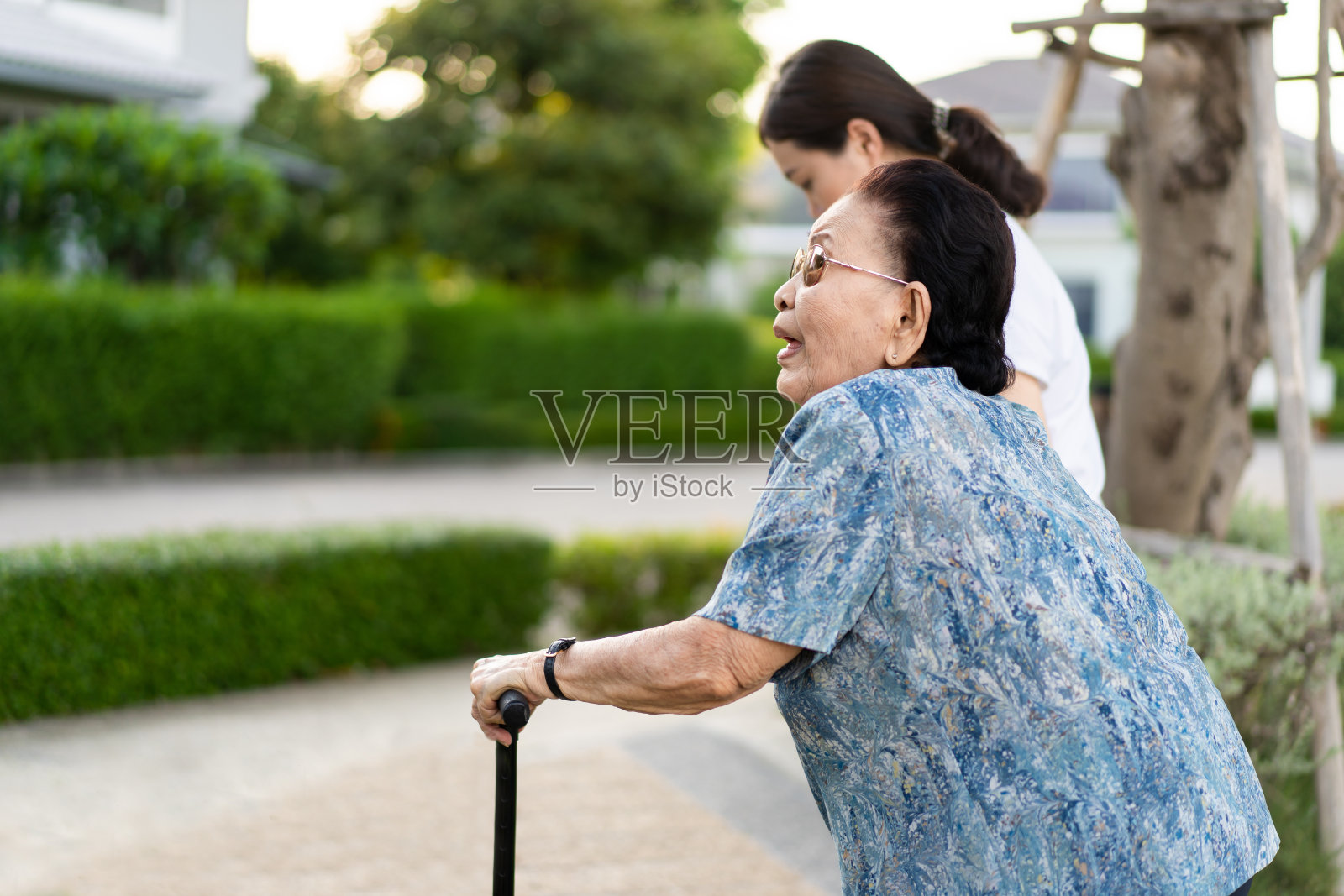 年轻女子与她的祖母散步。照片摄影图片
