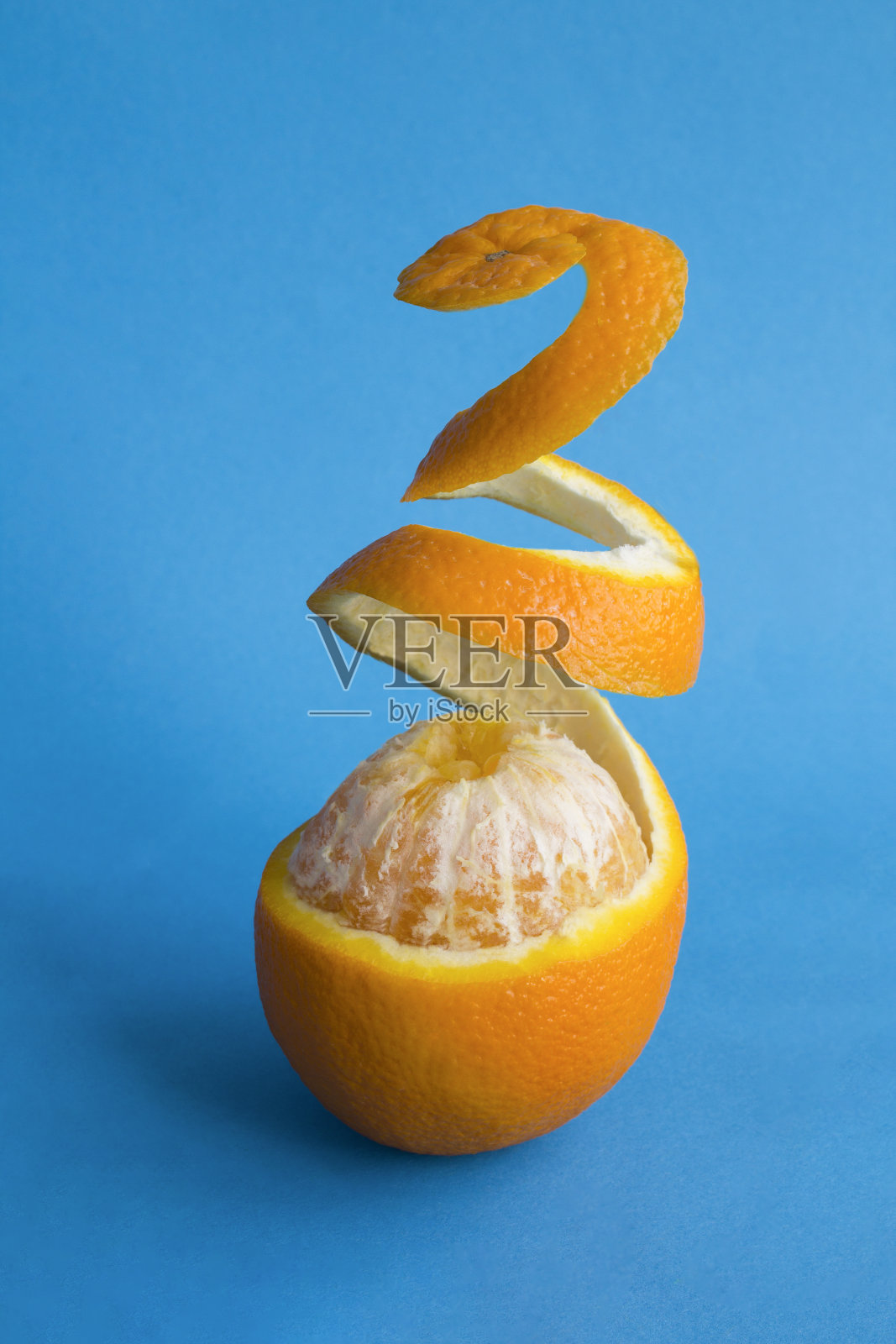 蓝色背景上剥皮的橙子水果特写照片摄影图片