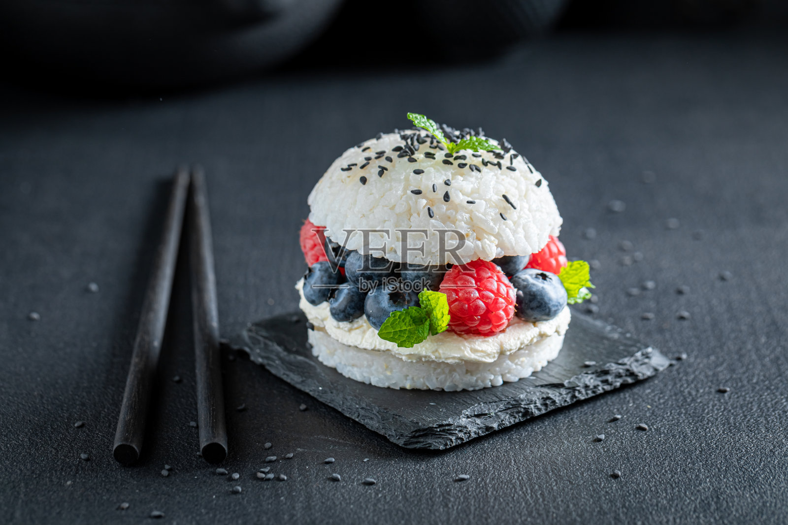 美味的寿司汉堡配上浆果和撒有种子的马斯卡彭奶酪。照片摄影图片