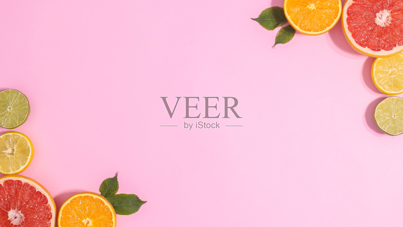 柔和的粉红色背景与切片柑橘水果在角落。复制空间平面纬度。夏天的概念照片摄影图片