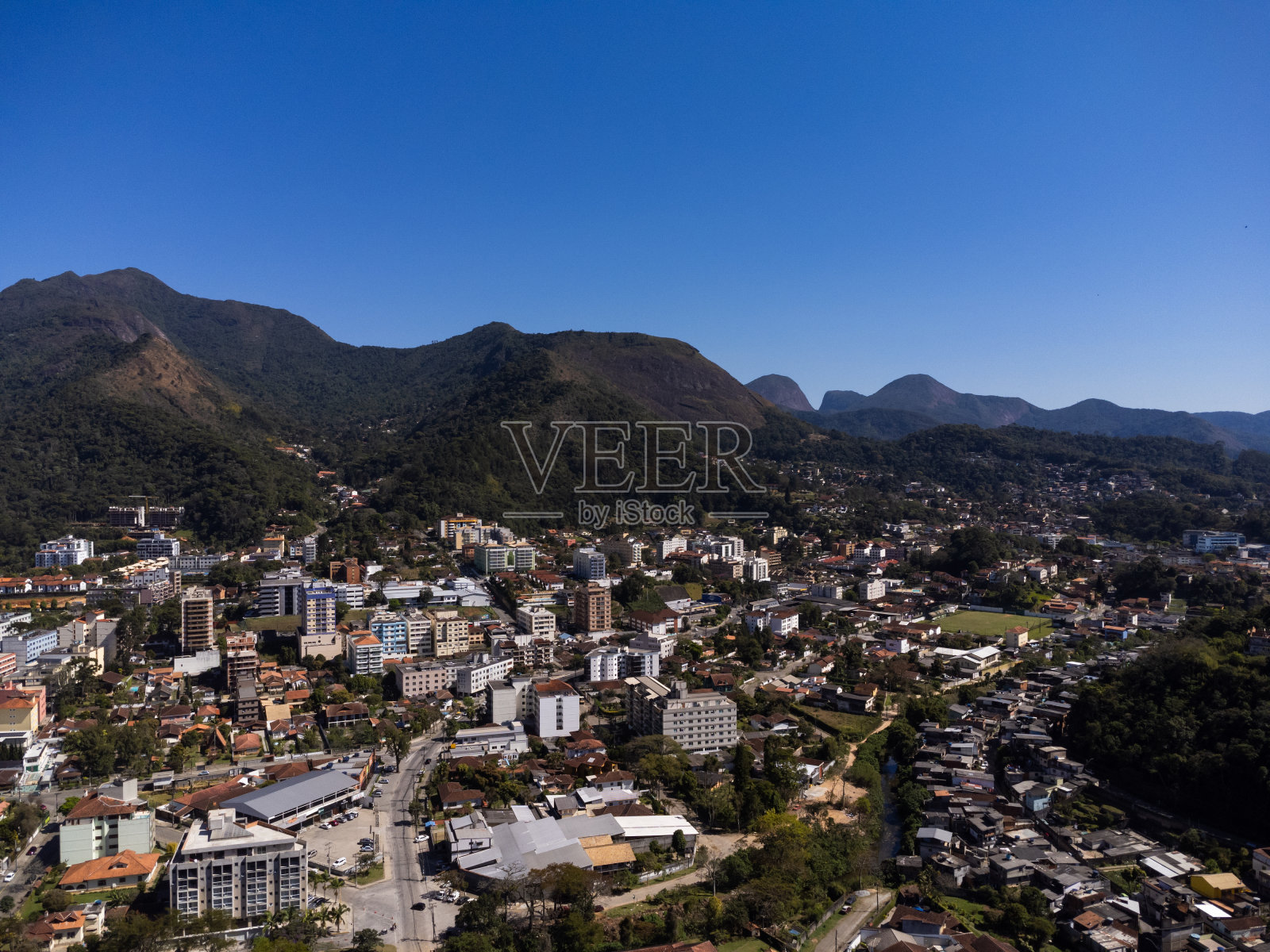 城市的鸟瞰图Teresópolis。在巴西里约热内卢的山区,有蓝色的天空和许多房子。无人驾驶飞机的照片。苏茜,Teresopolis。阳光明媚的一天。日出照片摄影图片