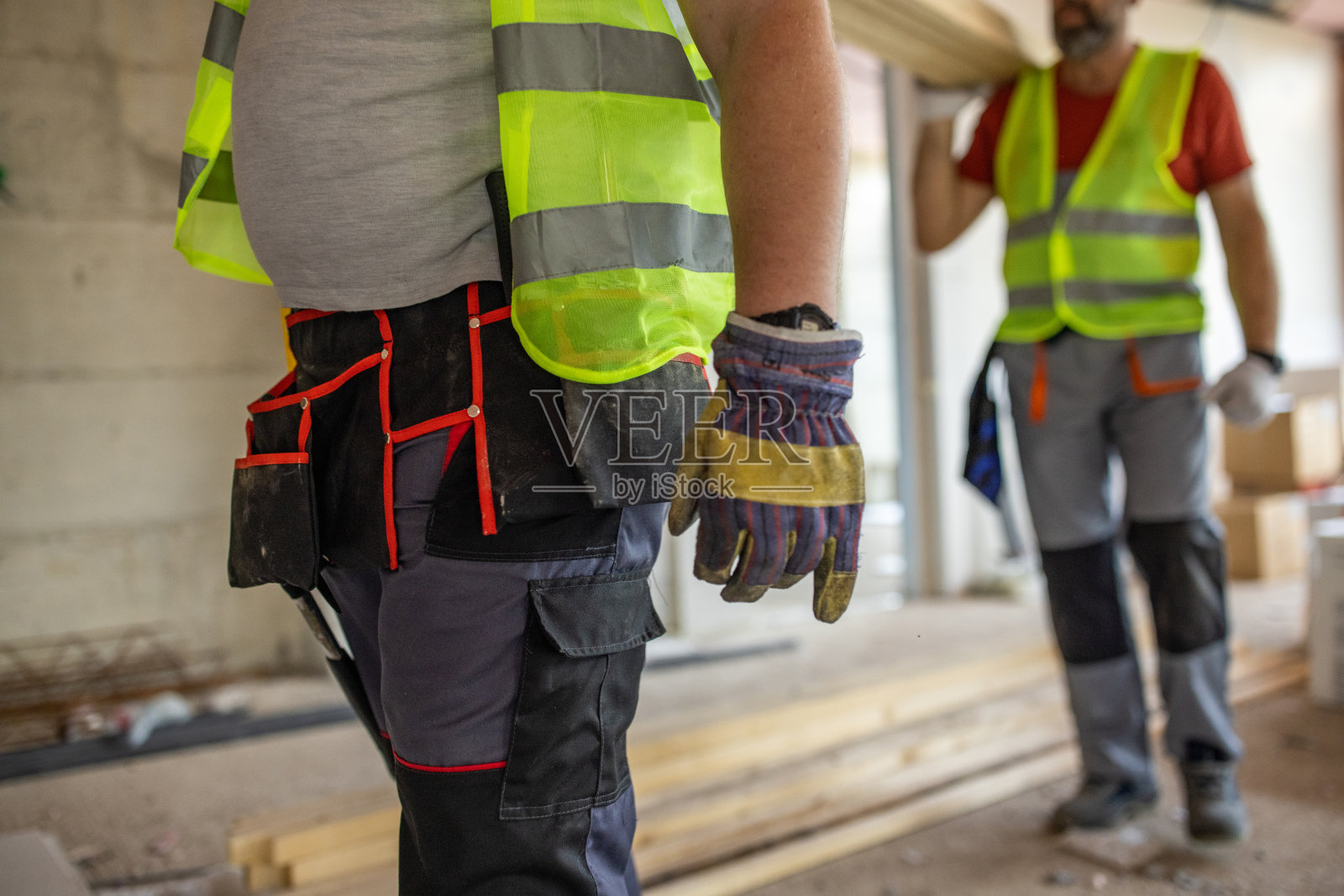 在建筑工地工作的陌生男性建筑工人正在搬运木材照片摄影图片