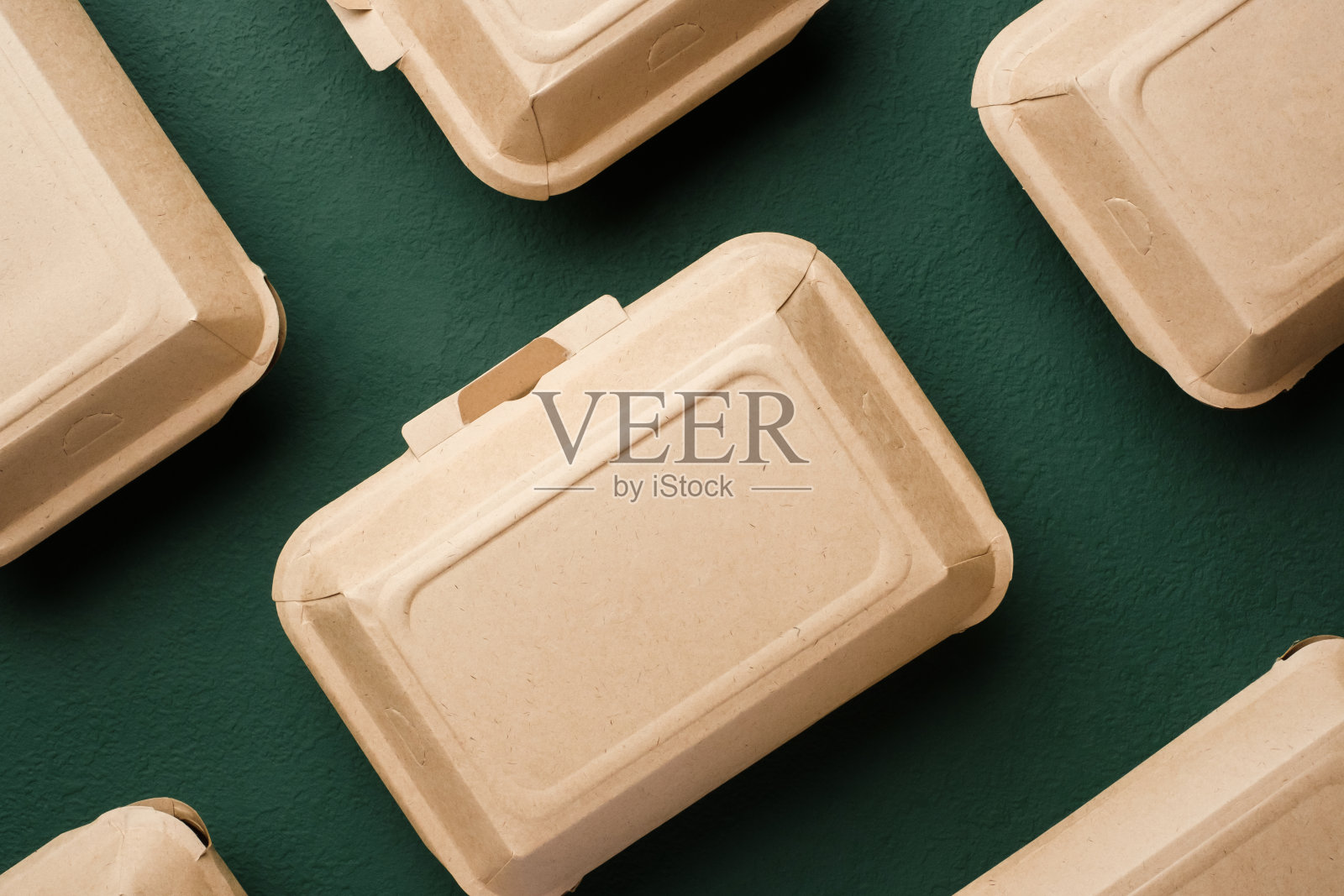 绿色背景的牛皮纸制成的环保一次性食品容器照片摄影图片
