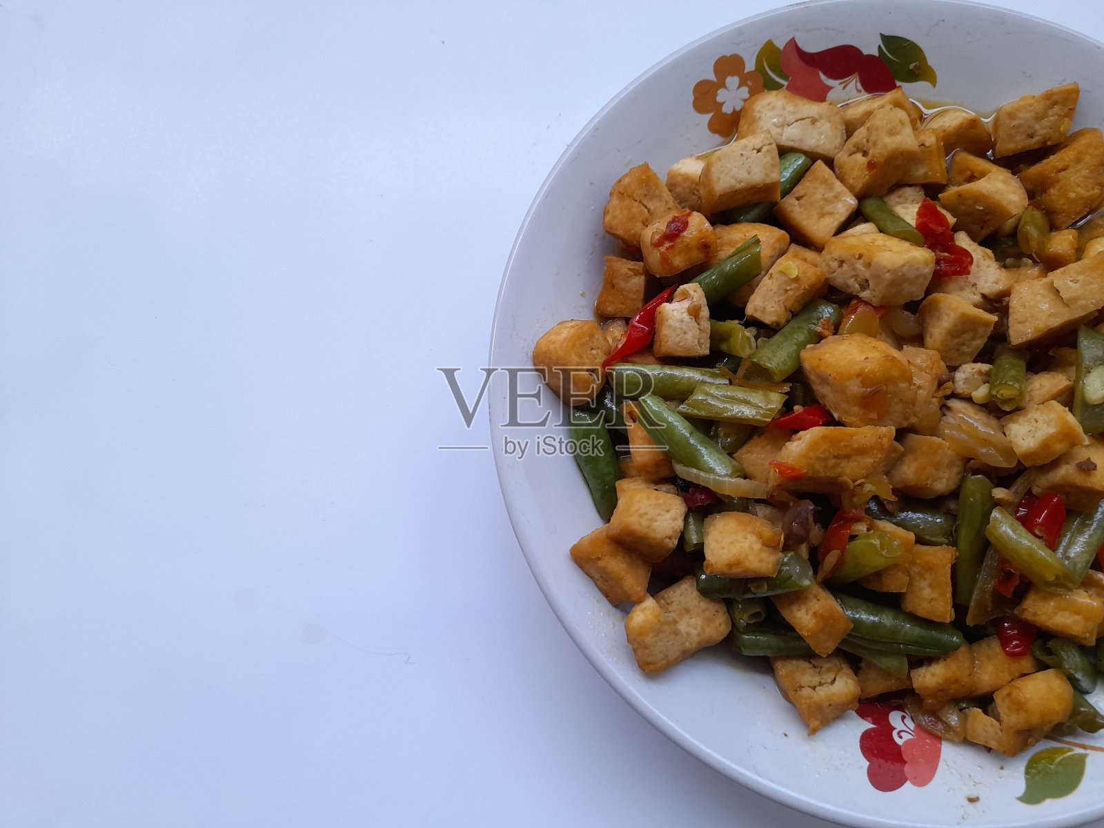 把豆腐和青豆放在盘子里翻炒照片摄影图片