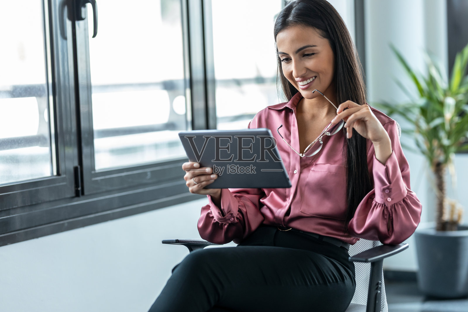 美容商务女性在现代创业公司的办公室工作时使用她的数字平板电脑。照片摄影图片