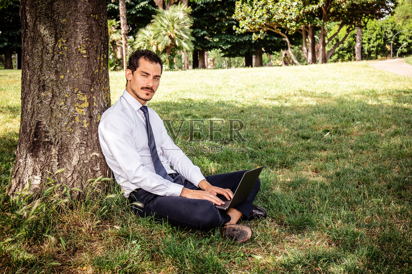 这位美丽的商人正在公园里工作。照片摄影图片