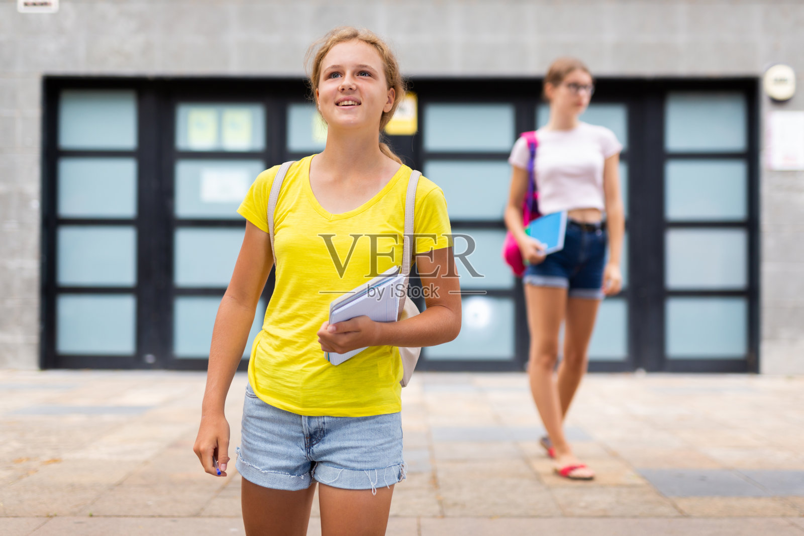 可爱的十几岁女孩走在街上上学照片摄影图片