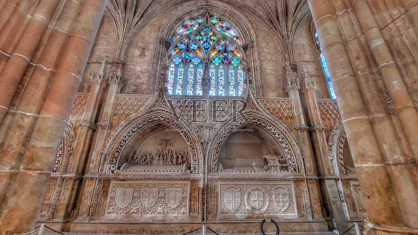 巴塔利亚修道院的内部,彩色玻璃窗在柱子和墙壁上折射出彩虹的倒影照片摄影图片