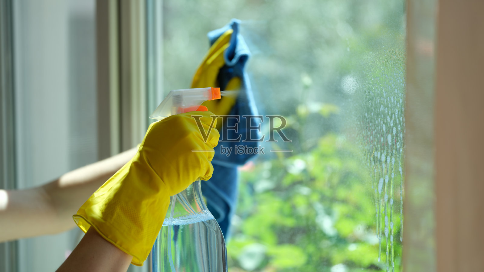 清洁剂在室内用清洁剂和抹布清洗窗户照片摄影图片