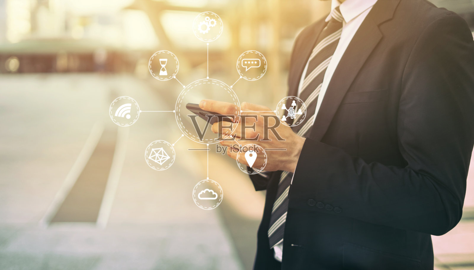 物联网(IOT)概念与年轻人手持智能手机的移动网络通信技术,图中显示了许多连接设备的图标。照片摄影图片