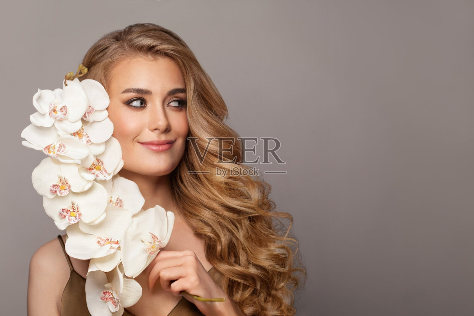 迷人的年轻女子与美丽的长卷发。时尚模特肖像在白色背景照片摄影图片