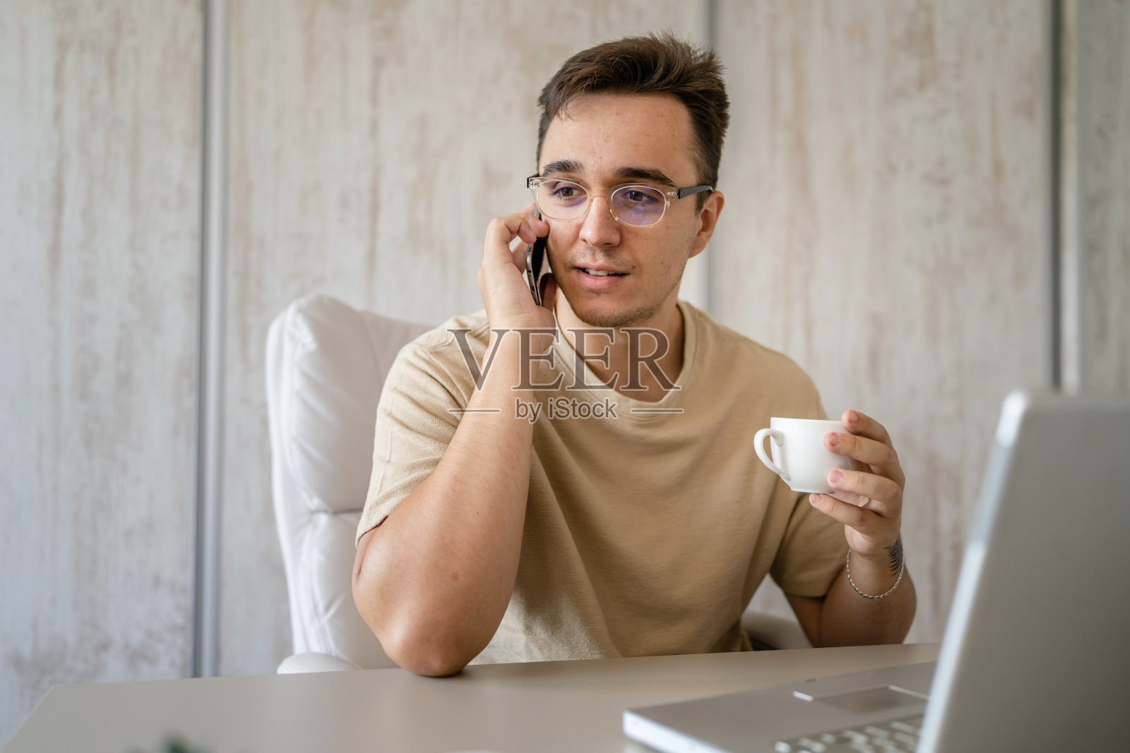 一名白人男子在办公室工作时打电话照片摄影图片