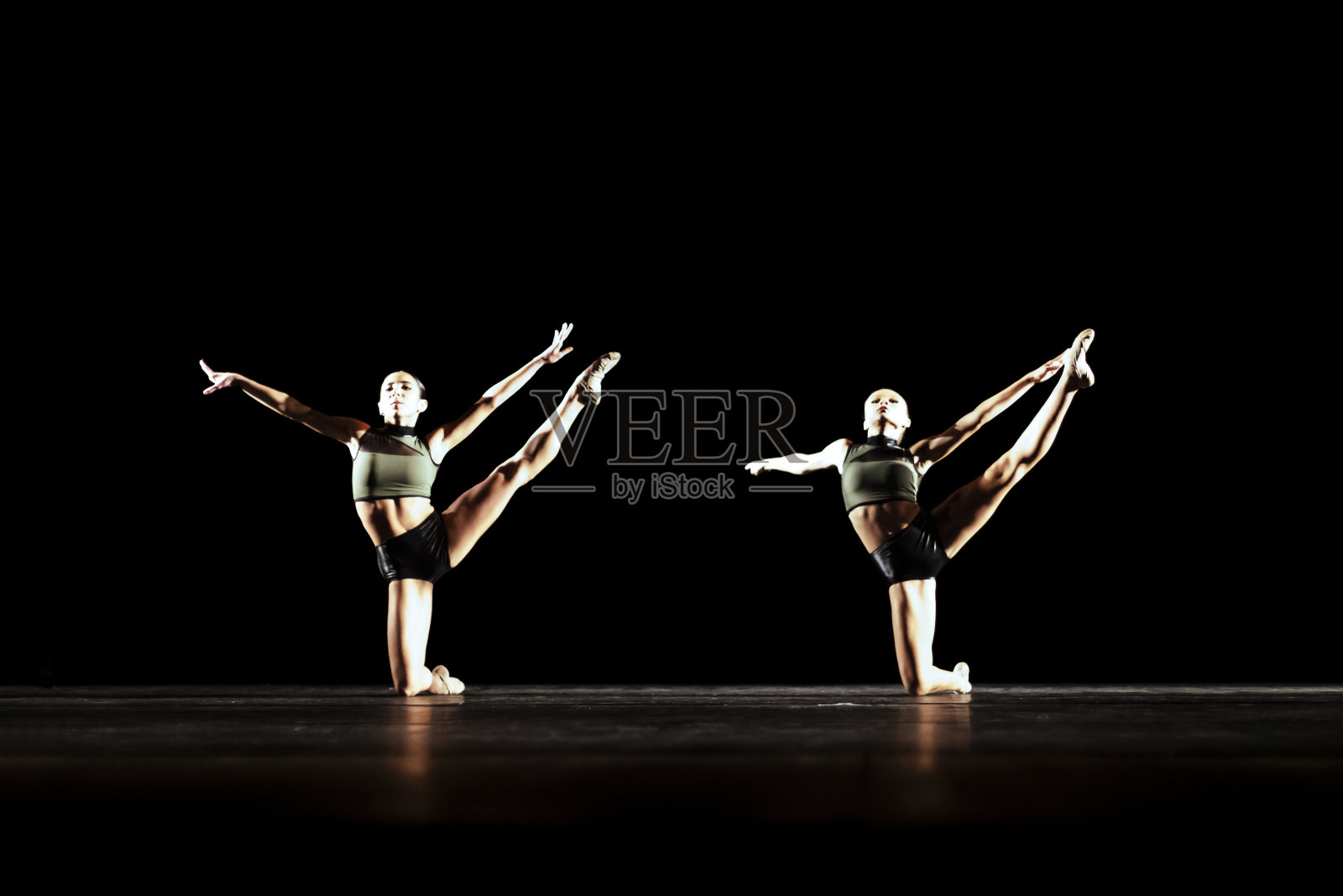 在黑暗的舞台上表演现代舞的少女二重唱照片摄影图片