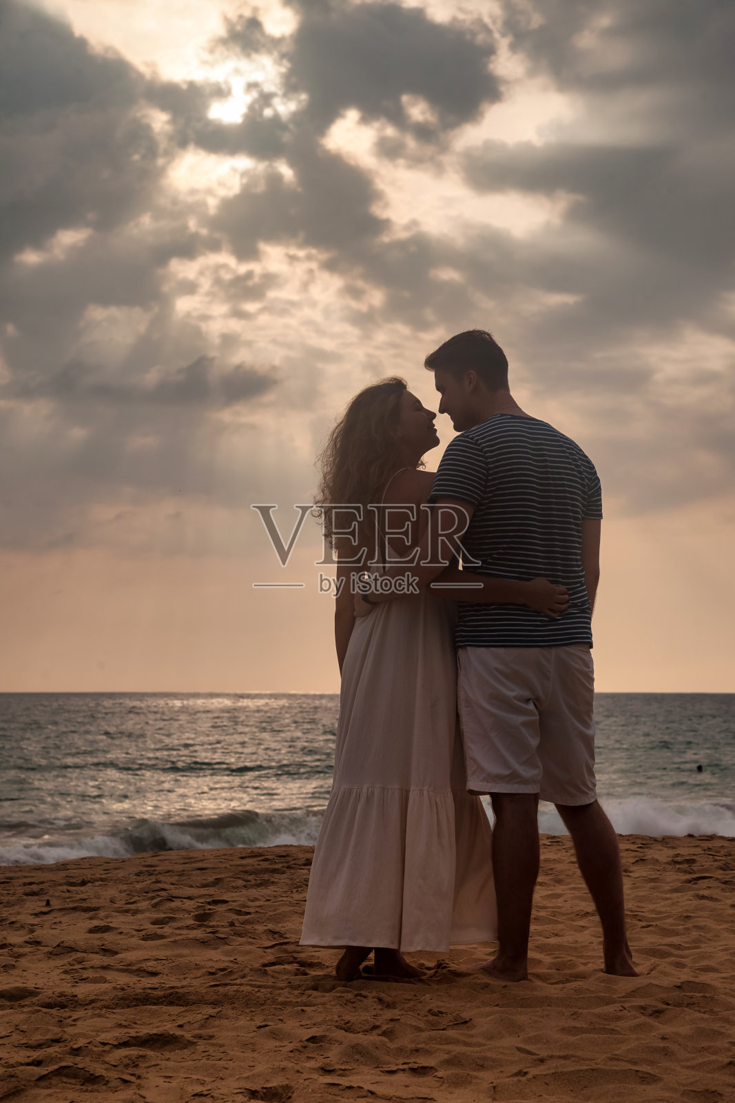 剪影幸福夫妇在热带沙滩在海上日落的背景。一对法国夫妇在海边享受夏天。可爱的男人和女人看起来幸福。复制文本空间照片摄影图片