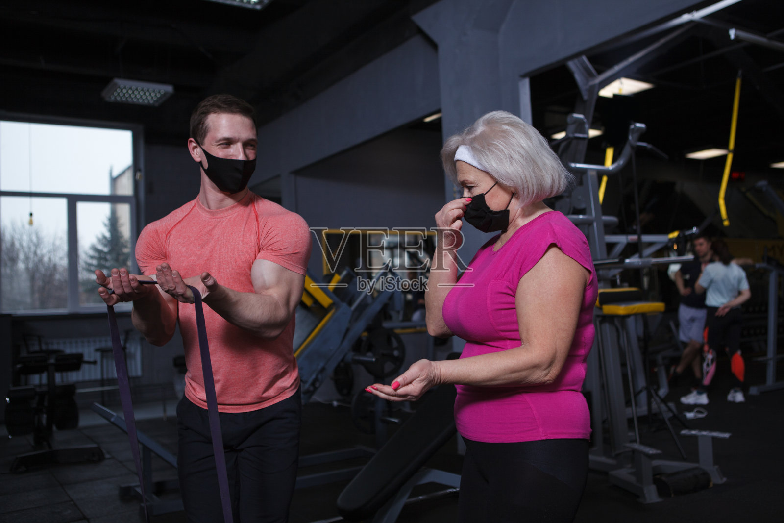 高级女性锻炼与私人教练在健身房照片摄影图片