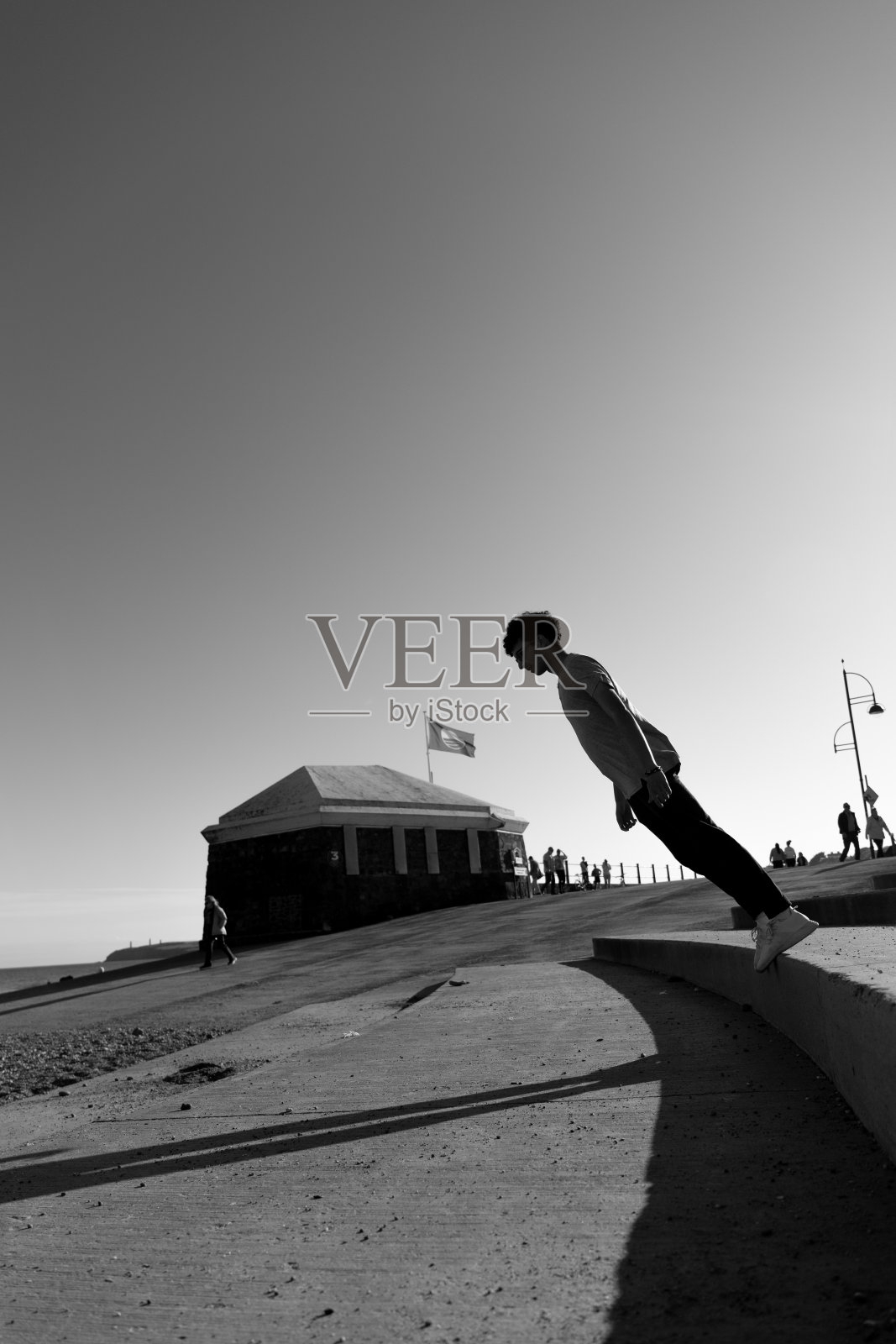 单色艺术肖像,一个年轻的少年弯腰几乎倒在地上照片摄影图片