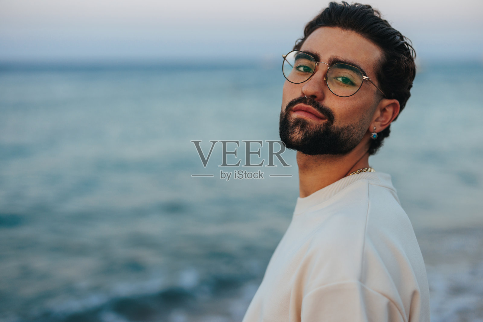 年轻男子在海滩上的肖像。照片摄影图片