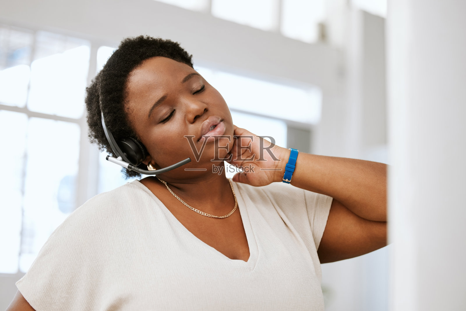 压力大,颈部疼痛和疲劳呼叫中心工作人员拉伸不好,紧张或肌肉酸痛,而耳机工作。女性电子商务支持顾问加班或长时间坐在办公桌前照片摄影图片