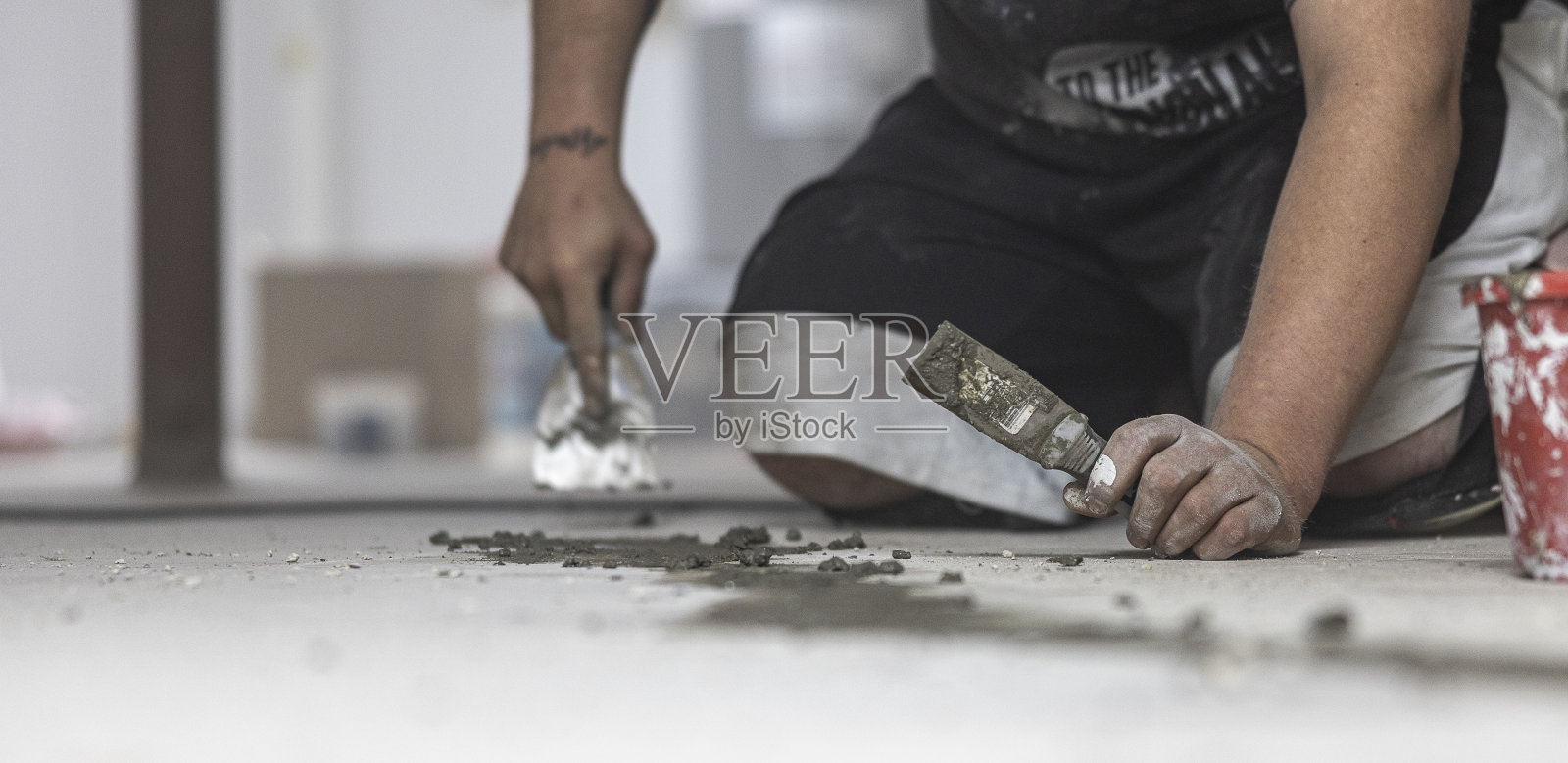 工人密封地下室地板裂缝,防止房屋霉变。照片摄影图片