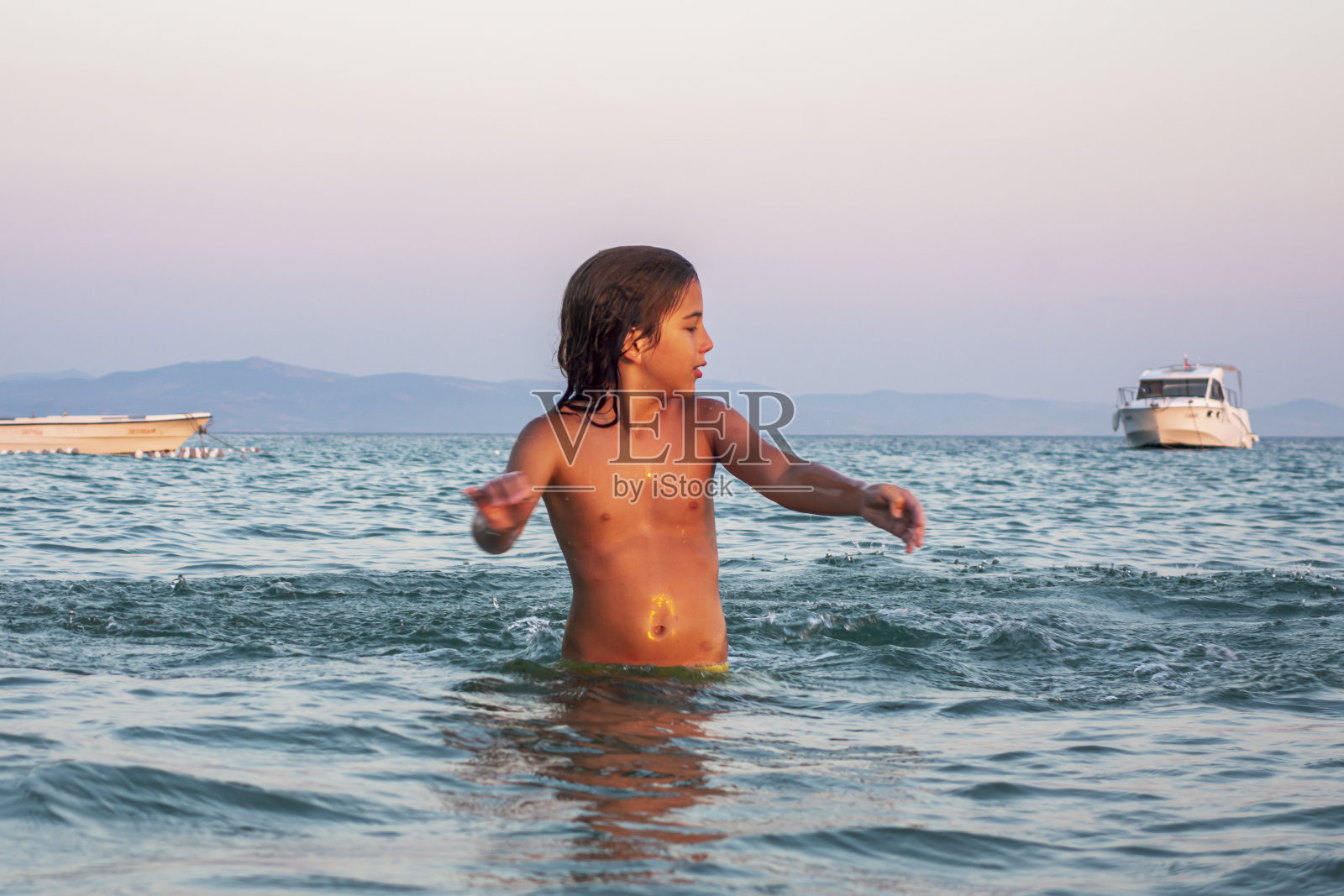 男孩在海里玩得很开心照片摄影图片