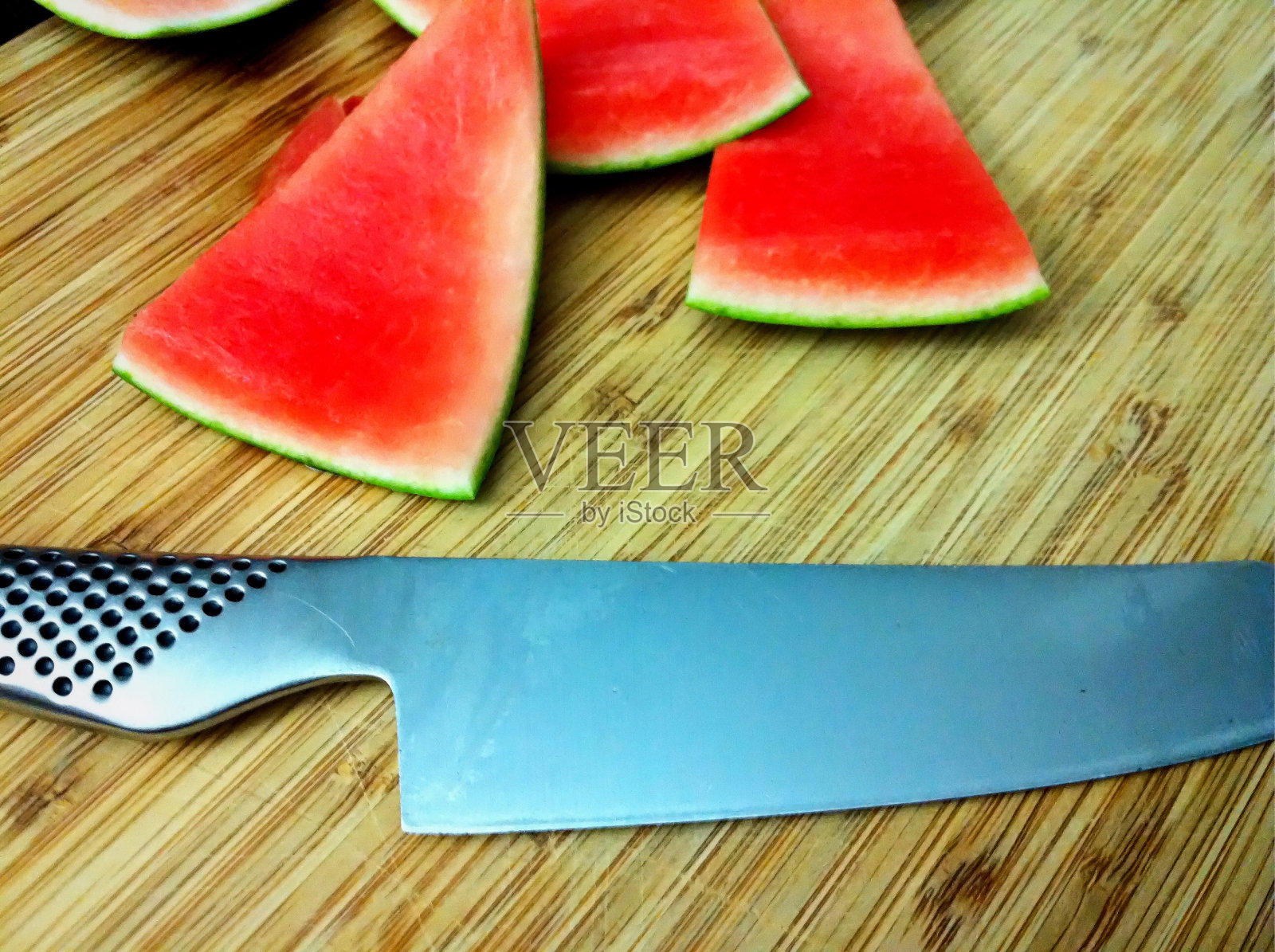 切菜板上放着西瓜和刀照片摄影图片
