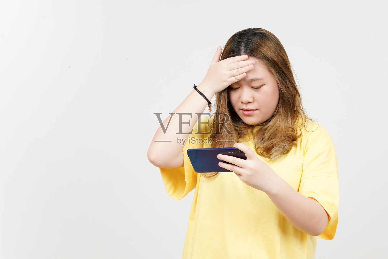 使用智能手机美丽的亚洲女人穿着黄色t恤孤立在白色背景照片摄影图片