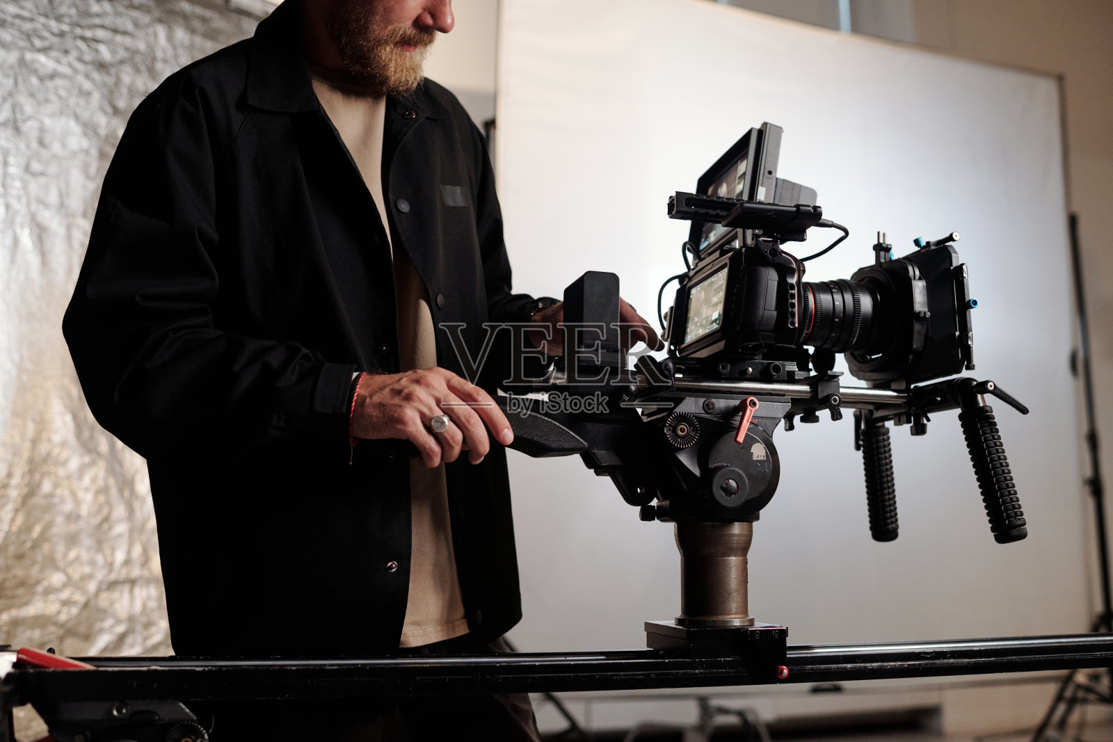 裁剪的年轻人穿着休闲装移动摄像机沿滑块照片摄影图片