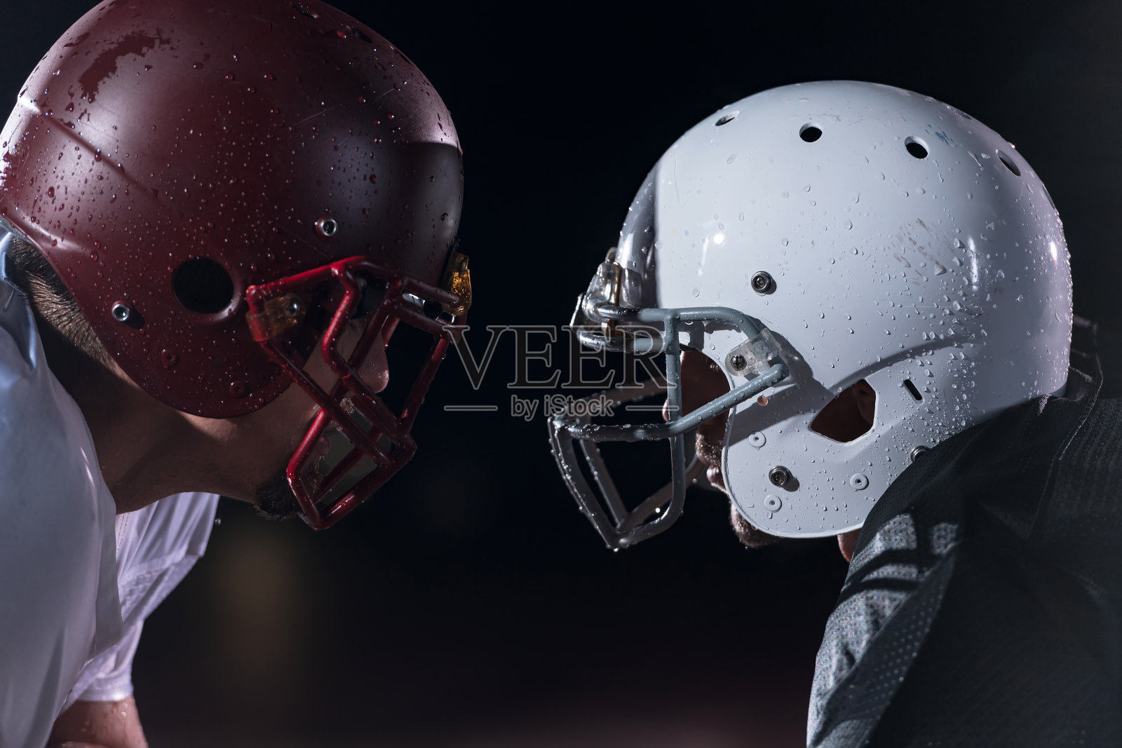 两名美式橄榄球运动员在白色背景上的剪影阴影中面对面照片摄影图片