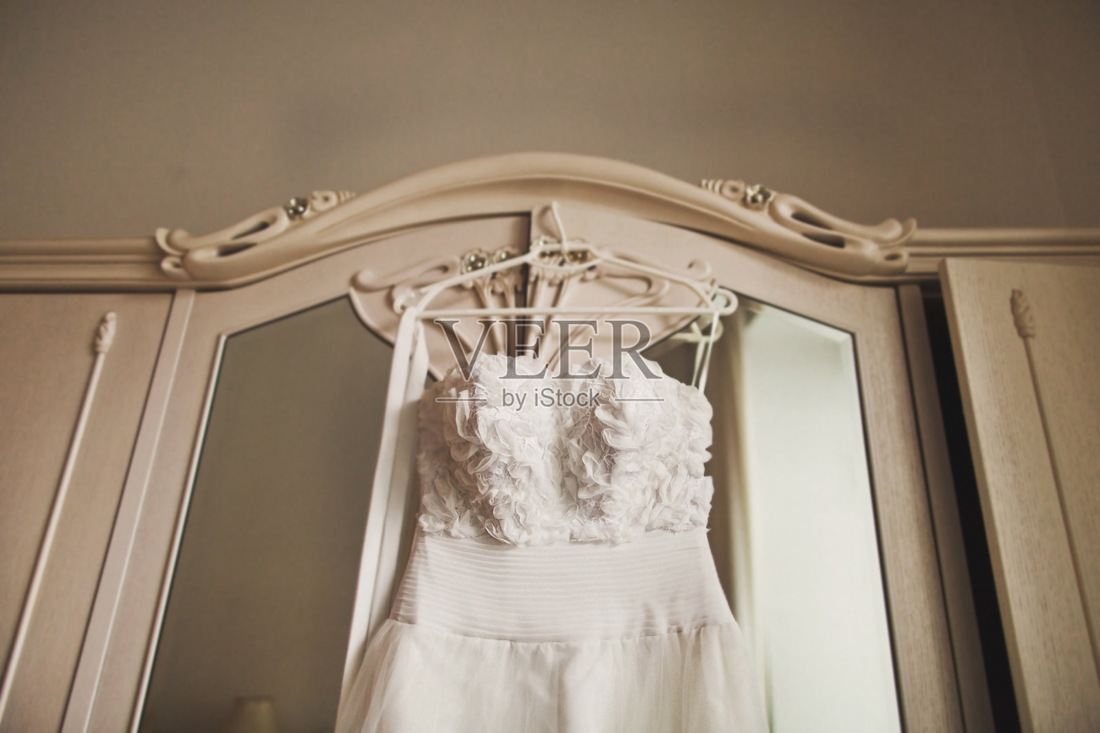 白色衣柜上挂着婚纱照片摄影图片